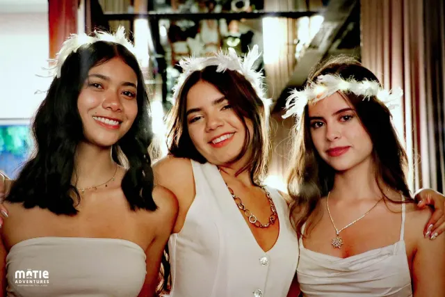 Alumnas con coronas de plumas blancas en un antro VIP de Vallarta