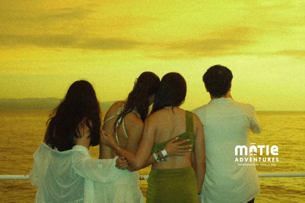Amigos de espaldas viendo el atardecer en la playa