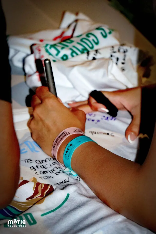 Hands holding a t-shirt signed by classmates