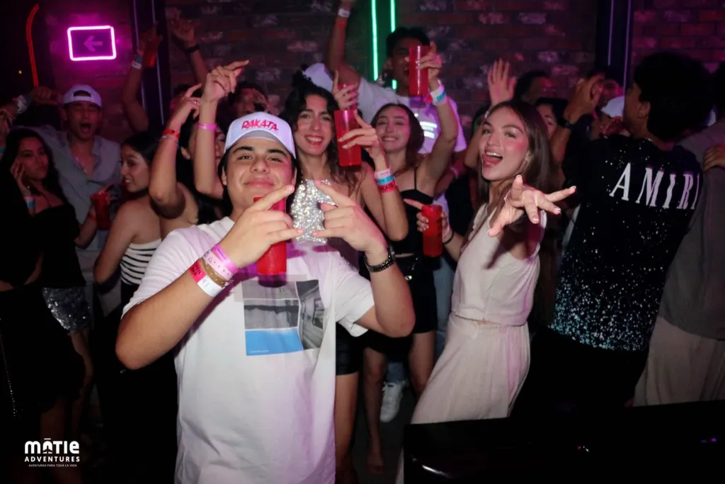 Grupo de viajeros MATIE celebrando de noche en una fiesta del viaje