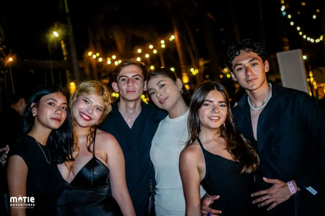 Grupo de amigos en el Golden Party frente a un corazón de luces doradas