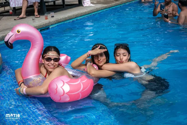 Pool with flamingo floats and confetti during the party