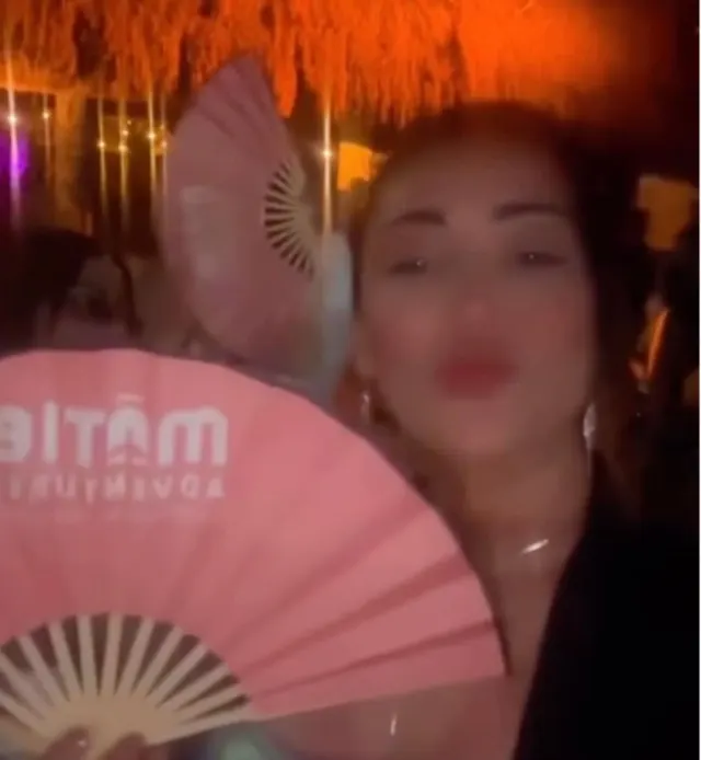 Clienta MATIE con un abanico de la marca en una fiesta nocturna en Tulum