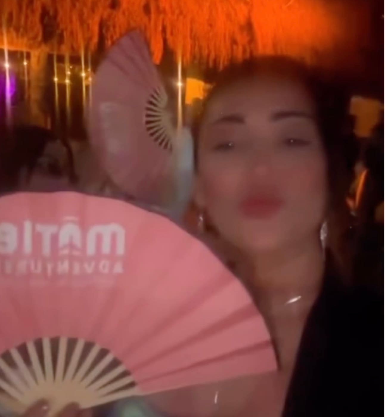 Viajera MATIE con un abanico de la marca durante una fiesta nocturna en Tulum